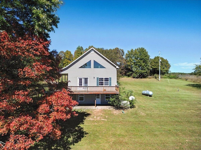 rear view of property featuring a yard, a patio area, and a wooden deck