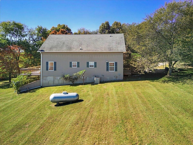 back of house featuring a wooden deck and a lawn