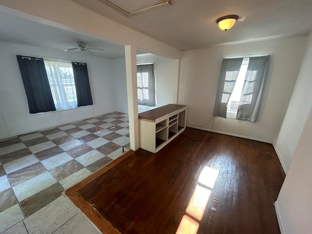 empty room featuring ceiling fan, a healthy amount of sunlight, and wood-type flooring