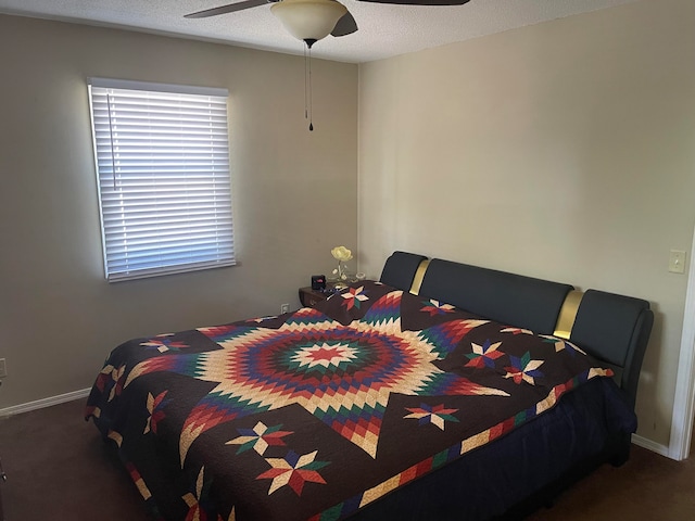 carpeted bedroom featuring ceiling fan and a textured ceiling