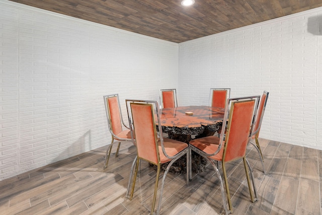 dining space featuring hardwood / wood-style floors, wood ceiling, and brick wall