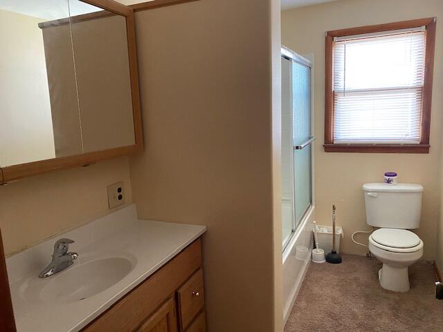 full bathroom with shower / bath combination with glass door, vanity, and toilet