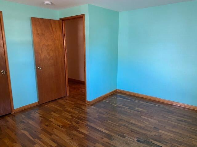 spare room with dark wood-type flooring