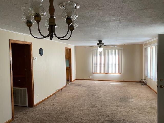 carpeted empty room featuring crown molding and ceiling fan