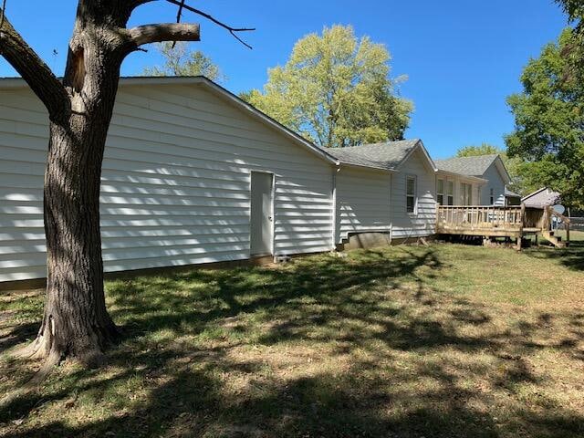 view of side of home with a yard and a deck