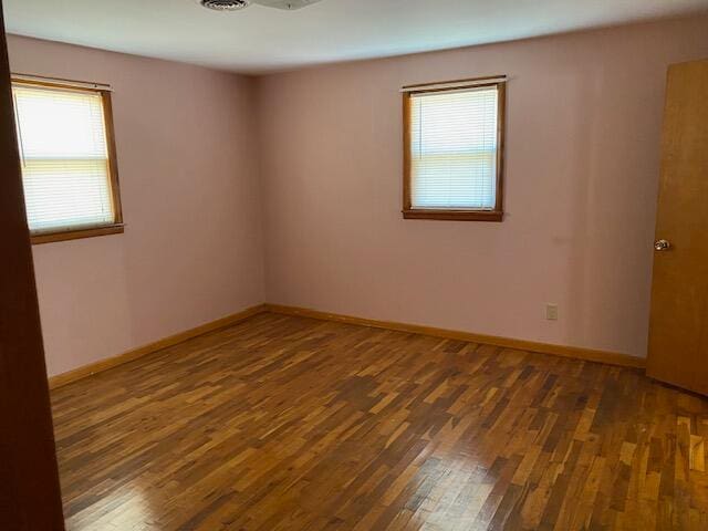 unfurnished room featuring dark wood-type flooring