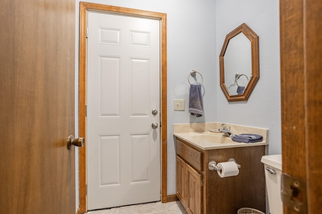 bathroom featuring tile patterned floors, vanity, and toilet