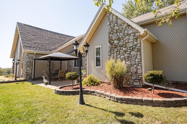 view of side of home with a gazebo, a patio area, and a lawn