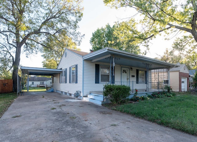 ranch-style home featuring a front lawn, a porch, and a carport