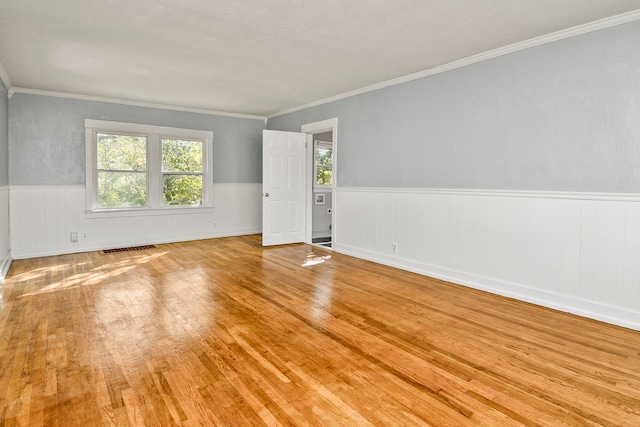 empty room featuring ornamental molding and light hardwood / wood-style floors