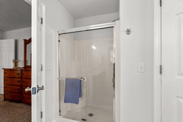 bathroom with walk in shower and a textured ceiling