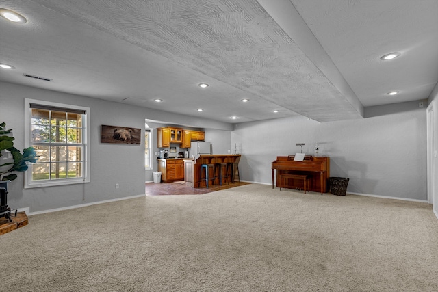 interior space featuring carpet floors, indoor bar, and a textured ceiling