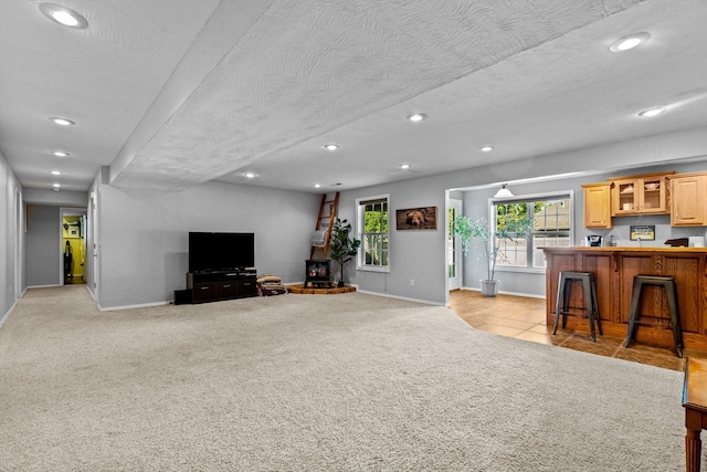 living room with light colored carpet, a textured ceiling, and bar