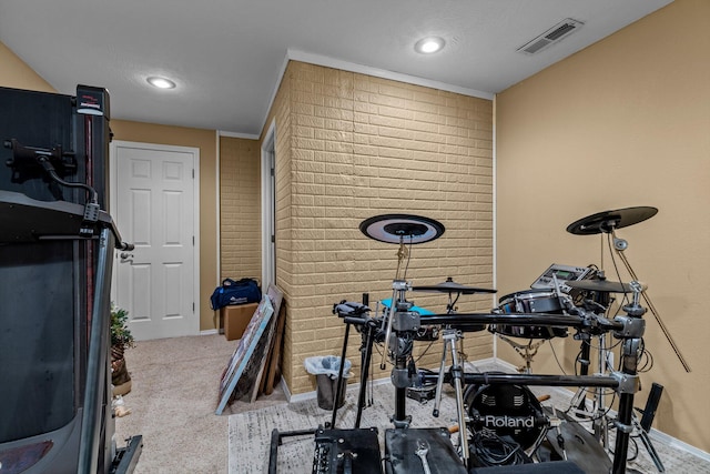 exercise area with brick wall, a textured ceiling, and light carpet