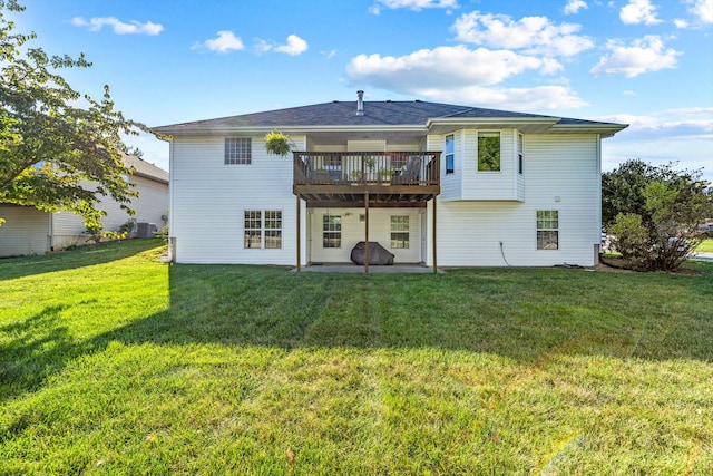 rear view of property featuring a deck, a lawn, and a patio