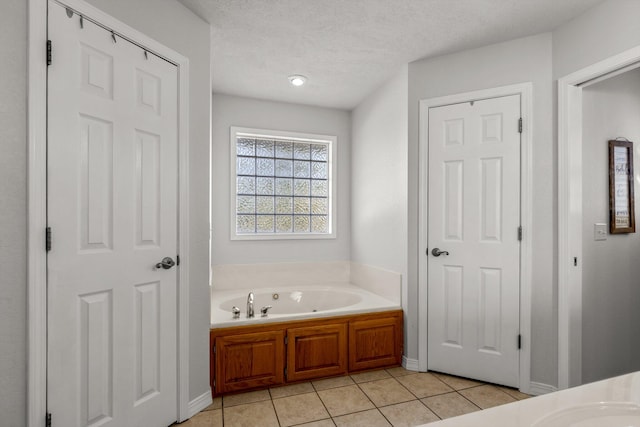 bathroom featuring a tub, tile patterned flooring, and a textured ceiling