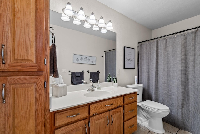 bathroom with tile patterned floors, vanity, toilet, and a textured ceiling