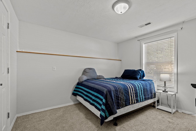 bedroom featuring carpet flooring and a textured ceiling