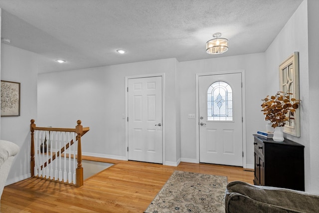 entrance foyer with light hardwood / wood-style flooring and a textured ceiling