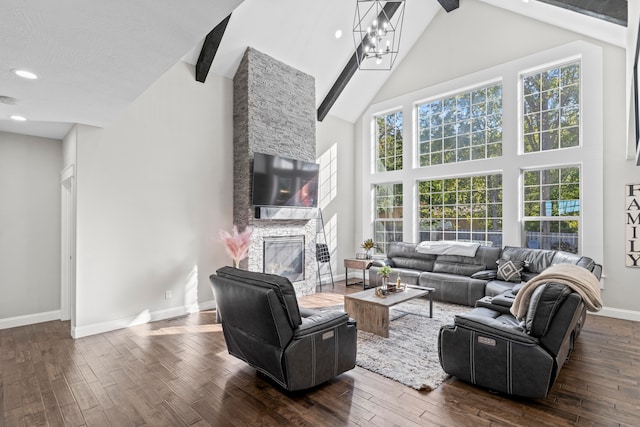 living room featuring beamed ceiling, an inviting chandelier, a stone fireplace, dark hardwood / wood-style floors, and high vaulted ceiling