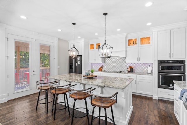 kitchen featuring white cabinets, appliances with stainless steel finishes, dark wood-type flooring, and a kitchen island