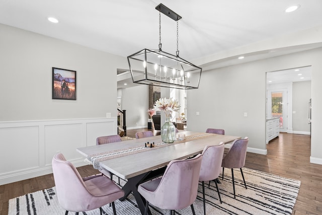 dining area with a notable chandelier and dark hardwood / wood-style flooring