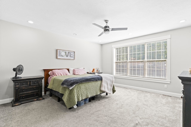 carpeted bedroom featuring ceiling fan and a textured ceiling