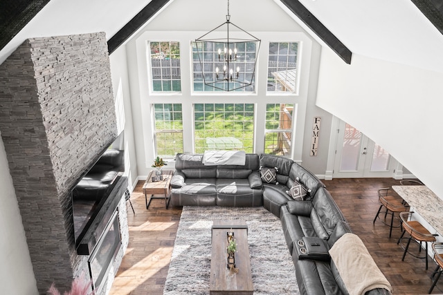 living room featuring beamed ceiling, dark hardwood / wood-style floors, a chandelier, and a wealth of natural light