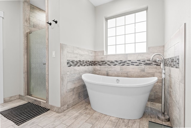 bathroom featuring separate shower and tub and tile walls