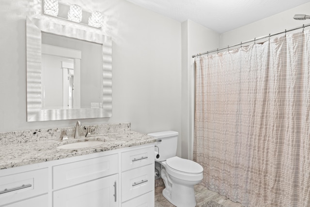 bathroom featuring walk in shower, toilet, hardwood / wood-style floors, vanity, and a textured ceiling