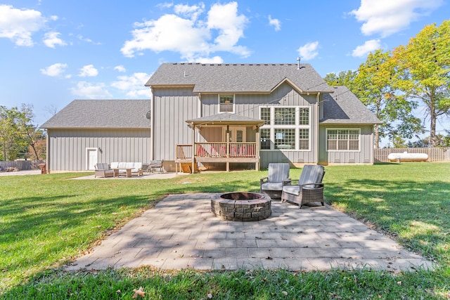 back of house with an outdoor living space with a fire pit, a lawn, and a patio area