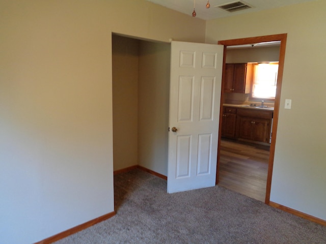 unfurnished bedroom with light carpet and sink