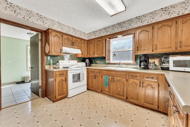 1400 W Oak St, Ozark, MO 65721 - kitchen featuring a sink, a textured ceiling, white appliances, brown cabinets, and under cabinet range hood