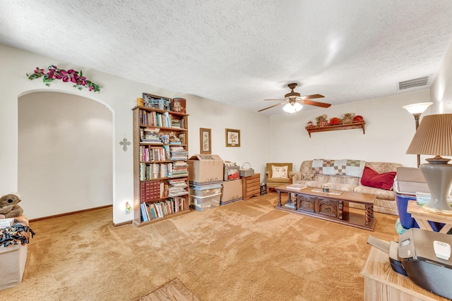 1400 W Oak St, Ozark, MO 65721 - carpeted living area with a ceiling fan, a textured ceiling, arched walkways, baseboards, and visible vents