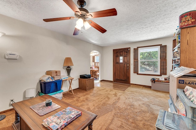 1400 W Oak St, Ozark, MO 65721 - carpeted living room with arched walkways, a textured ceiling, a ceiling fan, and baseboards