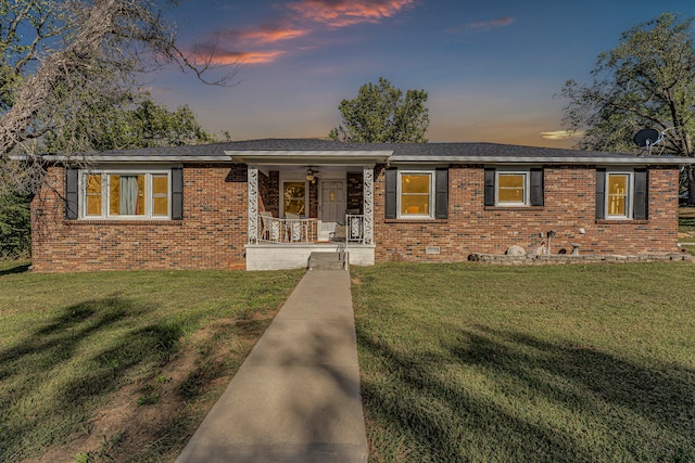 ranch-style house featuring a porch and a lawn