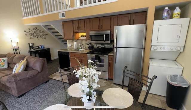420 Fall Creek Dr Unit 6, Branson, MO 65616 - kitchen with stacked washer and dryer, stainless steel appliances, a sink, open floor plan, and visible vents