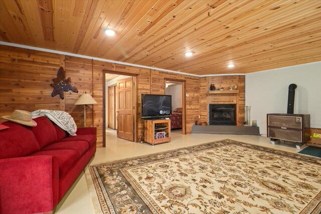 living area featuring crown molding, wooden walls, a fireplace, wooden ceiling, and recessed lighting