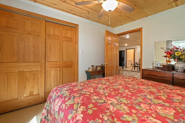 carpeted bedroom featuring ceiling fan, a closet, wood ceiling, and ornamental molding
