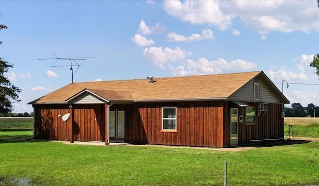 rear view of house featuring a yard and board and batten siding