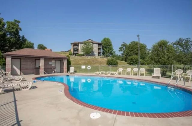 view of swimming pool featuring an outdoor structure and a patio