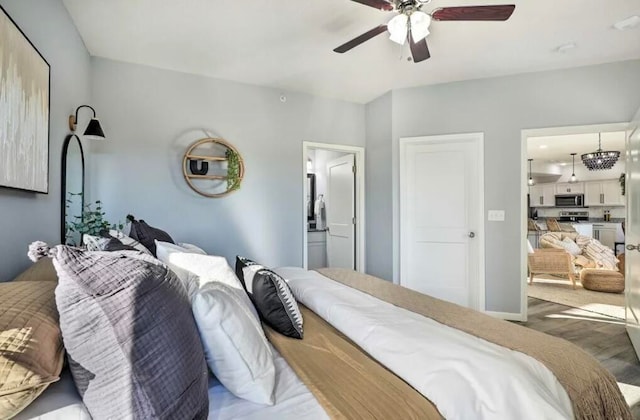 bedroom featuring hardwood / wood-style floors, connected bathroom, and ceiling fan