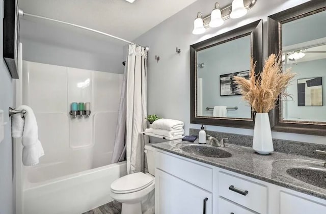 full bathroom featuring wood-type flooring, shower / bath combination with curtain, vanity, and toilet