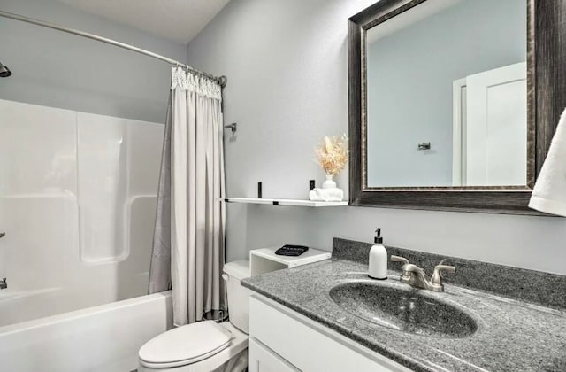 full bathroom featuring vanity, shower / bath combo with shower curtain, and toilet