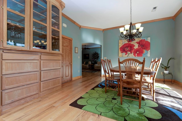 dining space with a notable chandelier, light hardwood / wood-style floors, and ornamental molding