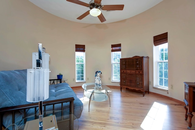 living area featuring ceiling fan, a wealth of natural light, and light hardwood / wood-style flooring