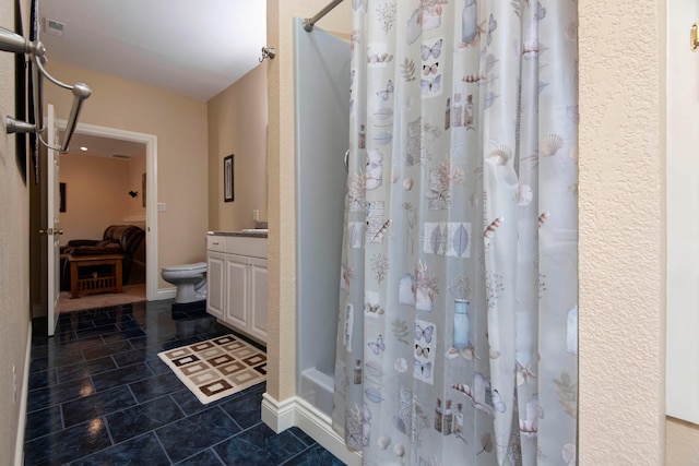 bathroom featuring toilet, tile patterned flooring, vanity, and curtained shower