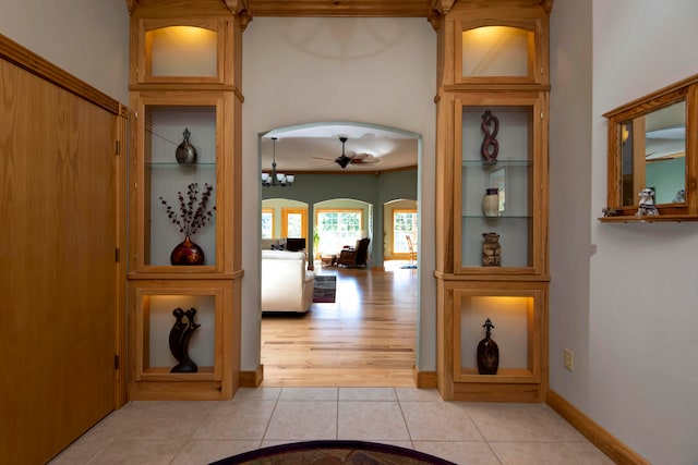 corridor featuring light tile patterned flooring and a chandelier