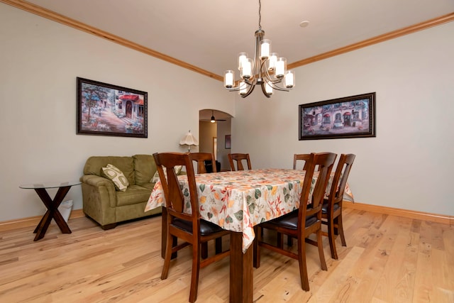 dining room featuring a notable chandelier, light wood-type flooring, and crown molding