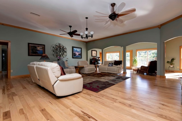 living room with ceiling fan with notable chandelier, light hardwood / wood-style flooring, and ornamental molding